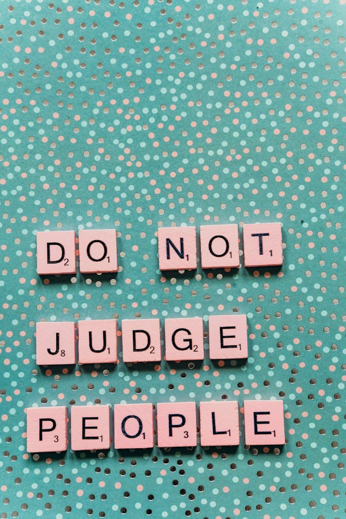 services-04 Inspirational Scrabble tile message 'Do Not Judge People' on teal polka dot background.